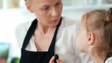 Annesi mutfakta kahvaltı yemek sırasında vakit ile neşeli küçük kız