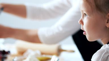 Küçük kızı annesi süzme peynir krep yemek pişirmek için yardımcı olur