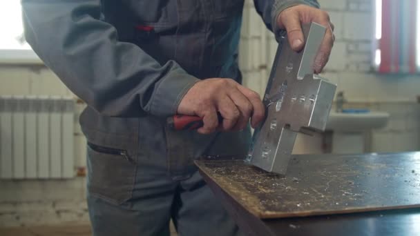 Mannelijke handen werken maalt de metalen body met een schraper — Stockvideo