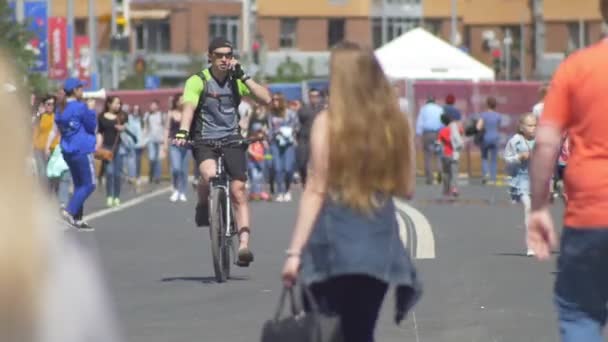 KAZAN, RUSIA - 16 DE JUNIO DE 2018: Copa Mundial de la FIFA - Multitud de personas caminando por la calle, dos hombres en bicicleta y hablando por teléfono — Vídeos de Stock