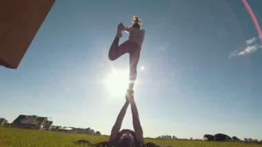 Açık tahta kuş gerçekleştirme kaç poz, Genç adam uçan kız kollarını çim üzerinde güneşli gün Dengeleme