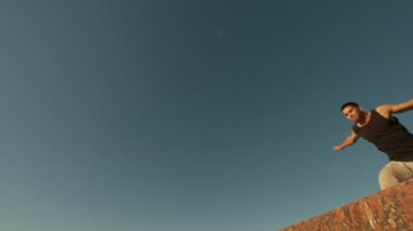 Kaslı adam gerçekleştirir son derece güneşli bir gün, yükseklikten fiske vurmak