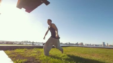 Kaslı adam flip iterek kapalı duvardan güneşli gün gerçekleştirir