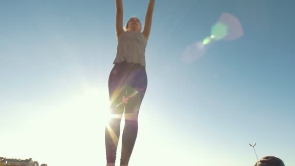 Giovane donna esegue lo spago in salto al sole — Video Stock