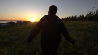 Yaz akşam sahasında güzel günbatımında yürüyen genç Afrika adam