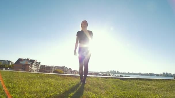 Junge Kaukasierin führt bei sonnigem Wetter akrobatische Sprünge im Freien auf — Stockvideo