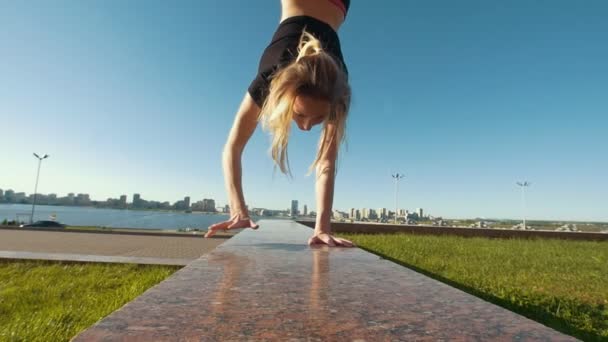 Junge kaukasische Cheerleaderin läuft bei sonnigem Wetter im Freien im Handstand — Stockvideo