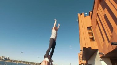 Açık havada, cityscape arka planda - genç amigo egzersiz genç adam gerçekleştirme kız flip havada