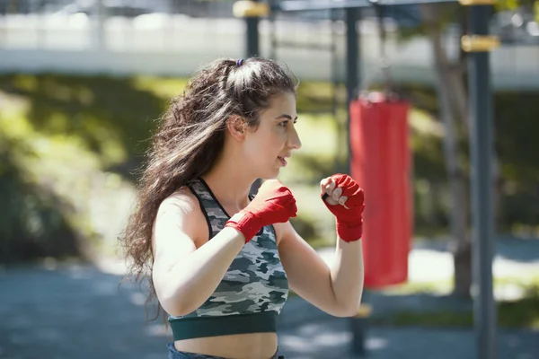 魅力的な若い女性のボクサーは、夏の公園での運動の位置に立っています。 — ストック写真