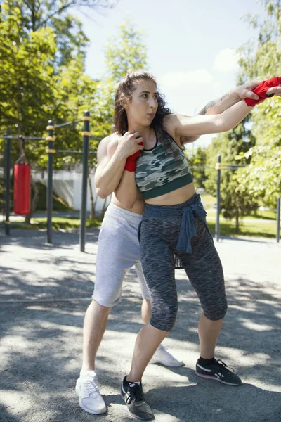 Boxare ung man innehav kvinna bakifrån, poserar en boxning punch — Stockfoto