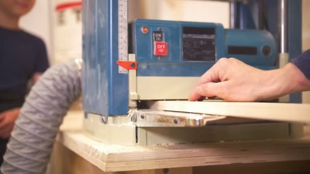 Artisan passe une poutre en bois à travers le concasseur de bois de menuiserie industrielle — Video