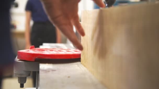 Mannenhand polijsten houten plank met behulp van industriële houtbewerking machine in werkplaats — Stockvideo