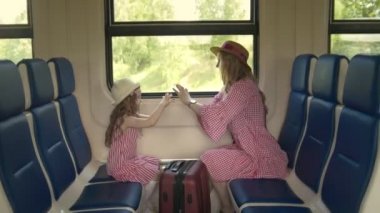 Güzel anne ve sevimli kızı patty-kek hızlı tren penceresinde önünde oturan oynarken