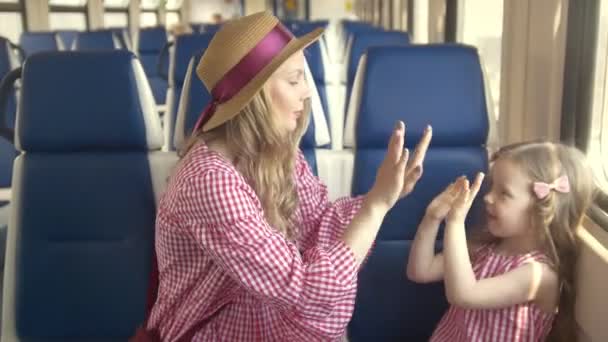 Fiatal anya és a játék patty-torta előtt ablak üres vonaton ülve, a kislányom — Stock videók