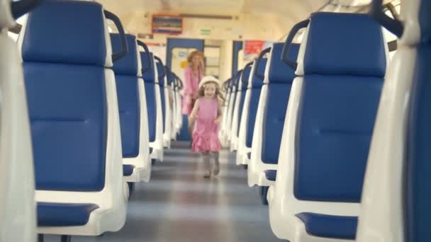 Feliz niña con su mamá huyendo en el vagón de tren vacío — Vídeo de stock