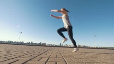 Genç kafkas kadın arka plan cityscape asfaltta akrobatik flip gerçekleştirir