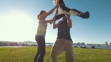 Ponpon kızlar takımı egzersiz açık havada, yaz günü - genç adam kızı çimlere düşer