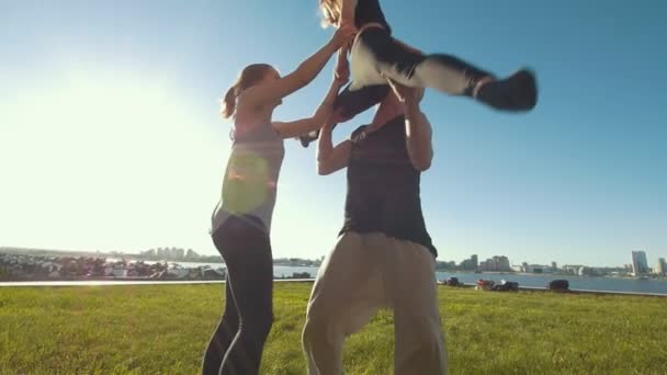 Animadoras equipo de entrenamiento al aire libre en el día de verano - hombre joven deja caer a la chica en la hierba — Vídeo de stock