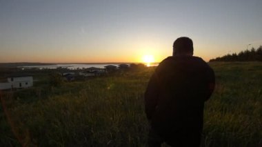 Yaz akşam sahasında güzel günbatımında yürüyen genç Afrika adam