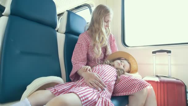 Jeune famille caucasienne voyageant dans le train - petite fille allongée sur les genoux de sa mère — Video