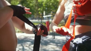 Atletik beyaz erkek ve kadın eller bandaj ile egzersiz için yaz park, kaydırma ağır çekim