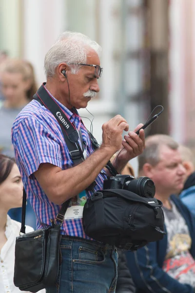 KAZAN, RUSIA - 21 de junio de 2018: Fotógrafo profesional de hombre maduro parado en la calle Bauman y usando un smartphone — Foto de Stock