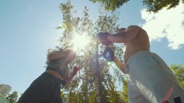 Çekici kadın genç kaslı adamla boks havada yaz gününde nişanlı.