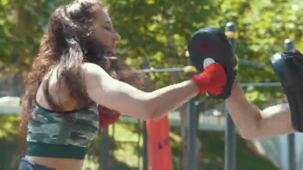 Boxeadores - hombre musculoso y mujer joven dedicada al boxeo en el parque ar día soleado — Vídeos de Stock