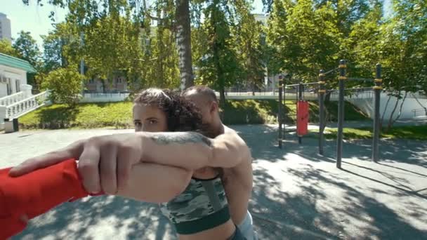 Боксер молодой человек держит женщину сзади, позирует боксерский удар, замедленная съемка — стоковое видео