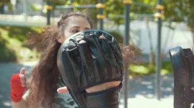 Boksörler - kaslı adam ve park ar güneşli gün boks yapan genç kadın