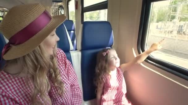 Feliz mamá e hija viajando juntas - va en el tren y mira por la ventana — Vídeos de Stock