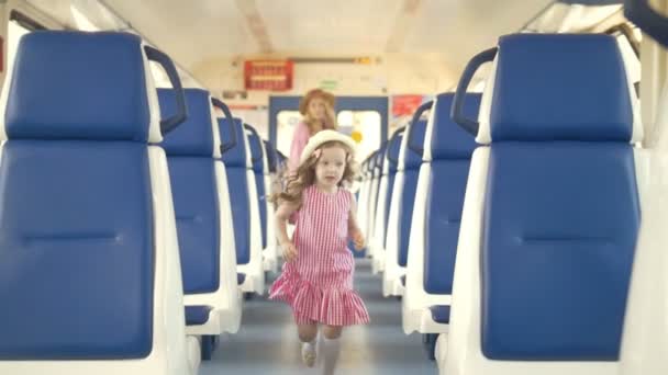 Attraktive junge Frau und ihre kleine Tochter laufen in leerem Eisenbahnwaggon — Stockvideo