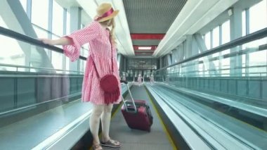 Anne ve küçük kızı Havaalanındaki yürüyen merdiven aşağı gidiş arkadan görünüş