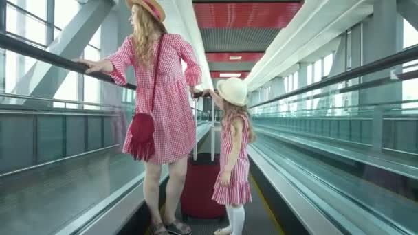 Junge attraktive Reisende steigt auf Rolltreppe am Flughafen — Stockvideo