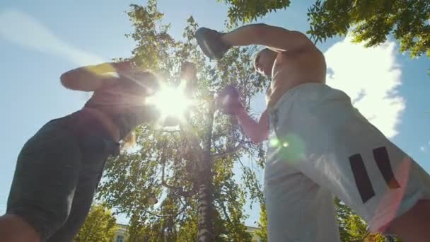 М'язистий чоловік і жінка займаються боксом з лапою під сонцем n літній день — стокове відео
