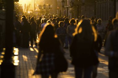 İki genç kadın kalabalığın içinde yaya caddesi üzerinde yaz gün batımında yürüme.