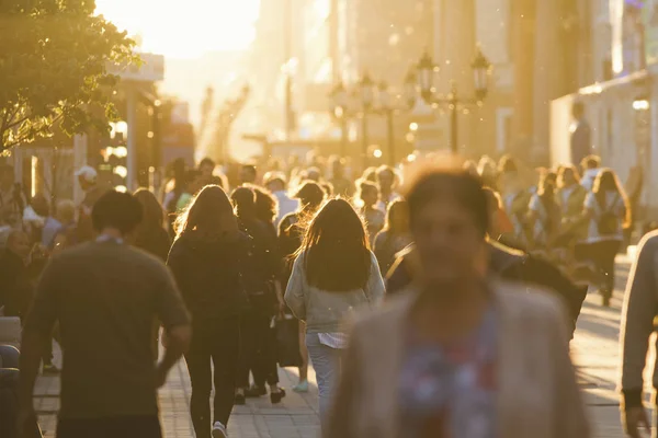 Silhuetas de pessoas multidão andando pela rua à noite de verão, luz bonita ao pôr do sol — Fotografia de Stock