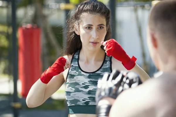 Boksörler - kaslı adam ve park ar güneşli gün boks yapan genç kadın