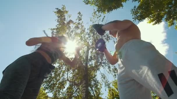 Musculoso hombre y mujer que participan en el boxeo con la pata bajo el sol n día de verano — Vídeos de Stock