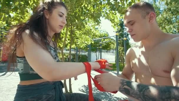 Atletische Kaukasische man en vrouw zittend op de Bank en wrappi — Stockvideo