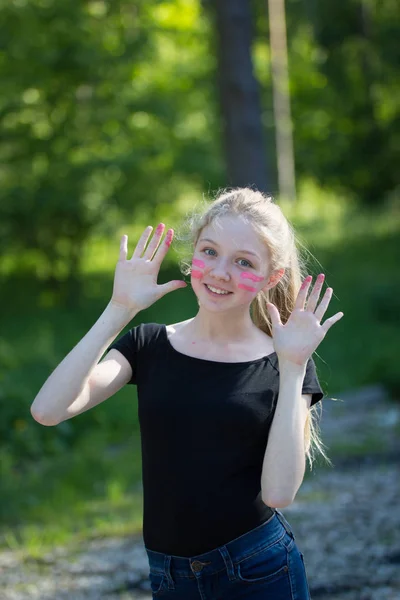 指塗料夏の公園で彼女の顔に笑みを浮かべて面白い十代の少女の肖像画 — ストック写真