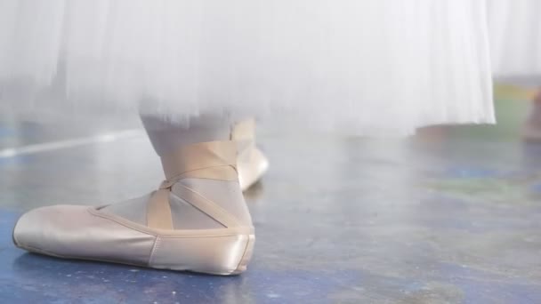 Kvinnliga fötter dansar i pointe skor framför ballerinor utför en dans i en studio — Stockvideo