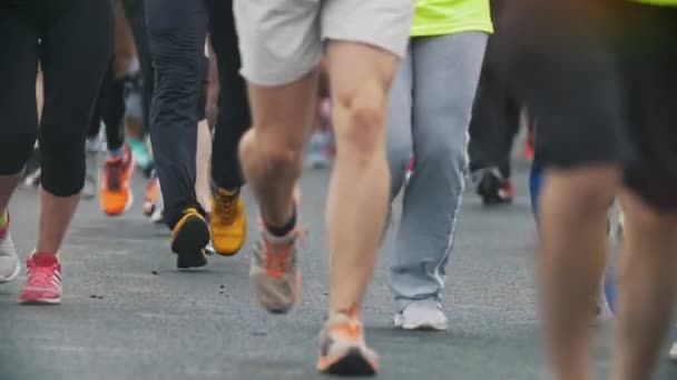 Біг - ноги спортсменів бігунів на марафоні в місті, повільному — стокове відео