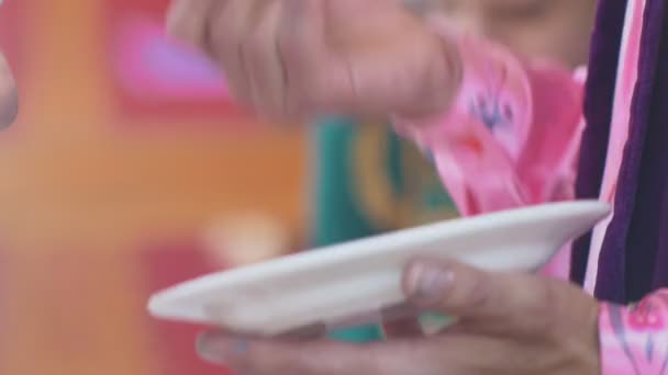 Руки зрелой женщины в народной одежде с краской, рисующей тарелки — стоковое видео