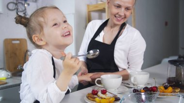 Genç anne çocuğunu birlikte ev yapımı kek pişirme ile