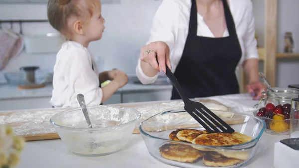 Roztomilý máma se svou malou dcerou vaření Tvarohové palačinky — Stock fotografie