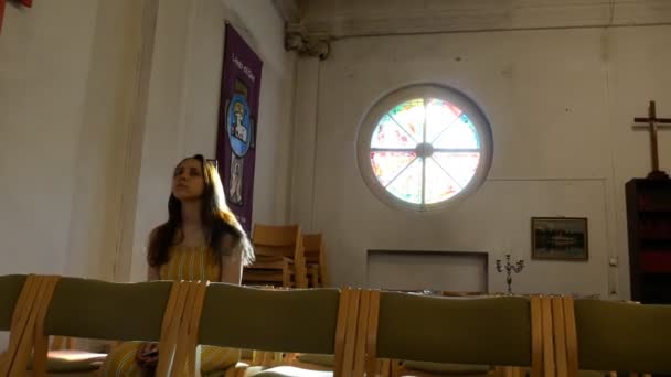 Giovane religiosa caucasica devota in panchina nella Chiesa cattolica — Video Stock