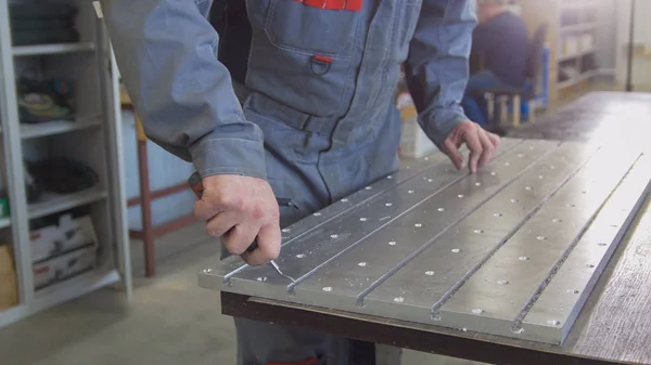 Mãos de trabalho masculinas moagem o corpo de metal com um raspador — Fotografia de Stock