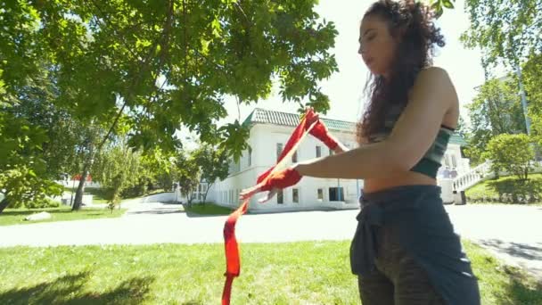 年轻妇女用红色绷带包裹她的手为拳击锻炼在夏天公园 慢的运动 — 图库视频影像