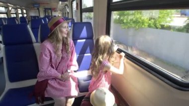 Mutlu anne ve kızı seyahat birlikte - trende gider ve pencereden dışarı bakmak